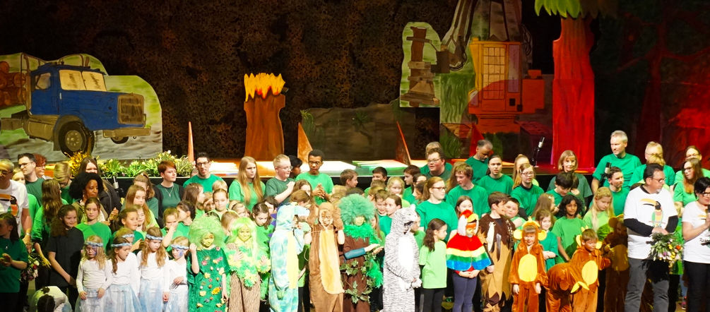 Ob Affenbande oder sprechende Baumriesen - eine bunte Schar von Schauspielern, Sängern und Musikern hat die Herzen des Publikums für den Schutz des Regenwaldes erobert Kinder stehen nach Aufführung auf der Bühne
