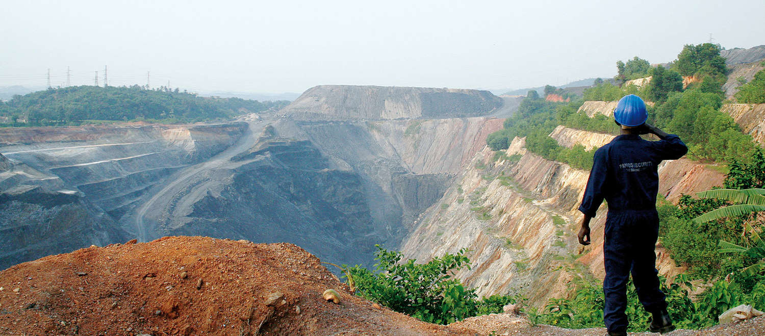Ein Arbeiter sieht in eine große Tagebau-Mine