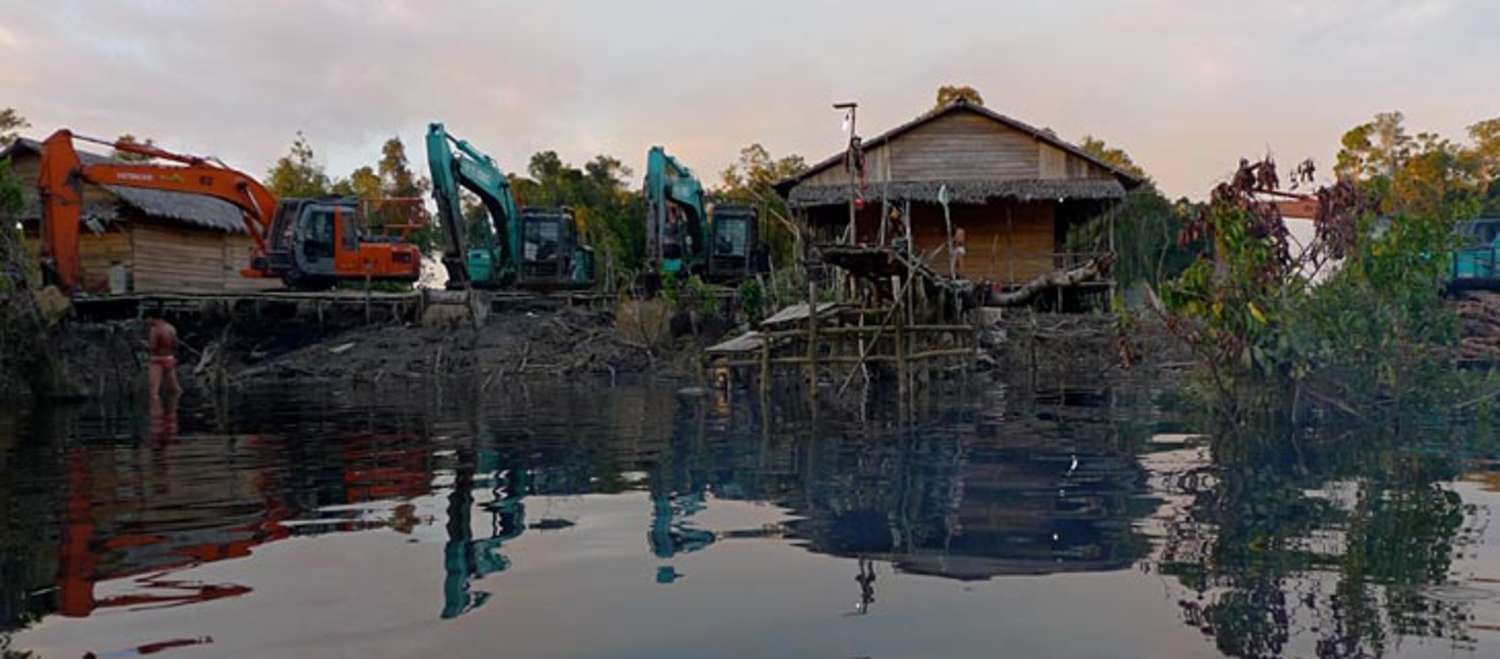 Bagger zerstören Häuser an einem Fluss in Indonesien