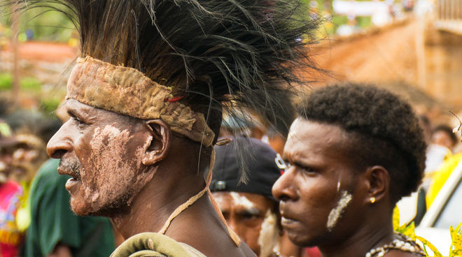 Die Mahuze wehren sich gegen Plantagen Männer mit Kopfschmuck bei einem Fest in Papua