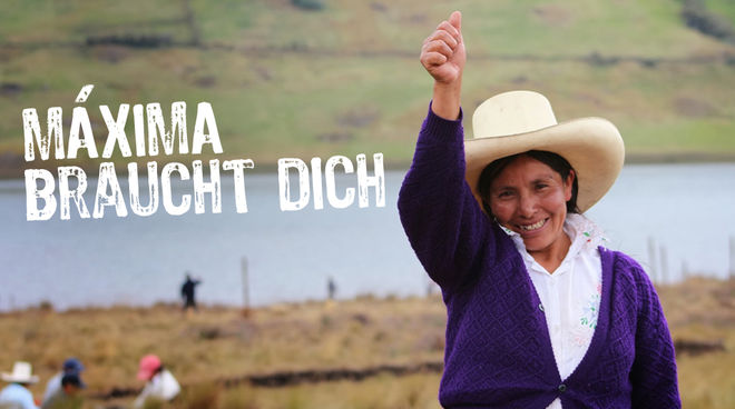 Máxima Acuña lässt sich nicht von den Bedrohungen einschüchtern und kämpft mutig um ihr Land Máxima Acuña erhebt lächelnd ihre rechte Hand. Im Hintergrund sind weitere Bauern und die blaue Lagune zu sehen.