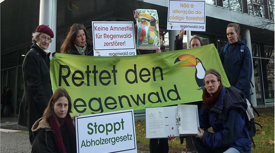 Demonstranten halten Transparente gegen Waldgesetz vor brasilianischer Botschaft