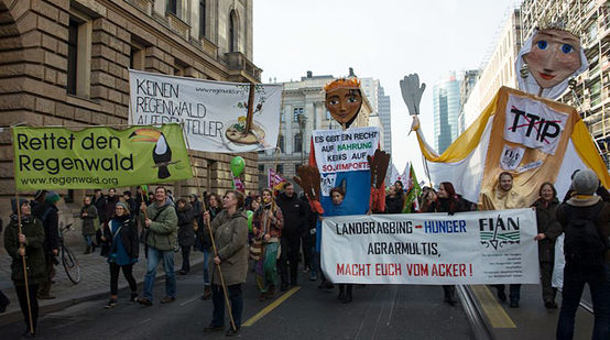 Demonstranten mit Banner von Rettet den Regenwald