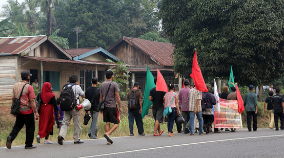 Einheimische aus Sumatra demonstrieren mit roten und grünen Fahnen