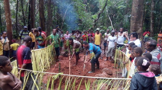 Die Indigenen Papuas stehen im Kreis und beobachten ein Ritual zum Schutz des Territoriums