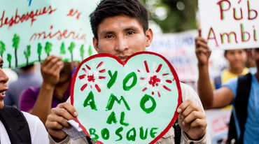 Ein Demonstrant in Iquitos, Peru, zeigt ein Herzplakat "Ich liebe den Wald" auf Demo gegen Abholzung für Kakaoplantagen