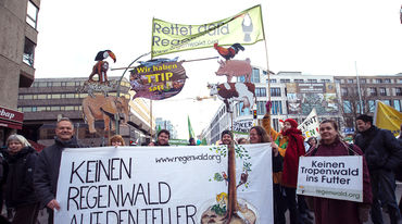 Demonstraten halten ein Banner: "Keinen Regenwald auf den Teller"