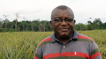 Odey Oyama vor Ananas Plantage