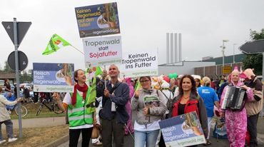 Regenwaldaktivisten halten bei der Schlachthofumzingelung in Wietze Plakate hoch.