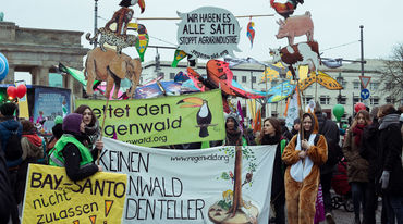 Aktivisten halten Banner und Plakate gegen Massentierhaltung in die Höhe