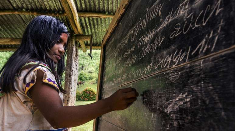 Eine junge Indigene der Ngäbe-Buglé schreibt auf einer Tafel