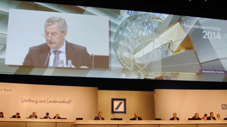 Deutsche Bank-Chefs Fitschen (oben) und Jain müssen sich unserer Kritik am Palmöl-Geschäft stellen Deutsche Bank-Chef Fitschen während der Hauptversammlung auf dem Podium