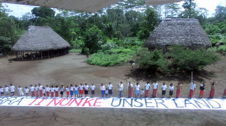 Die Indianer in einem Dorf im Amazonasregenwald richten sich mit einem Banner an die Öffentlichkeit: Dies ist unser Land.