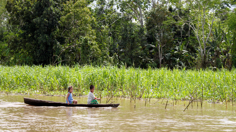 Zwei Kinder fahren auf dem Amazonas-Fluss Boot
