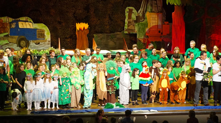 Ob Affenbande oder sprechende Baumriesen - eine bunte Schar von Schauspielern, Sängern und Musikern hat die Herzen des Publikums für den Schutz des Regenwaldes erobert Kinder stehen nach Aufführung auf der Bühne