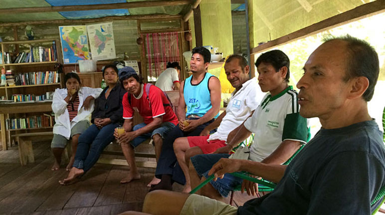 Peruanische Kleinbauern sitzen zusammen und diskutieren über Naturschutzmaßnahmen