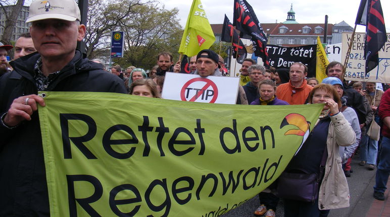 Aktivisten von Rettet den Regenwald tragen ein großes Banner