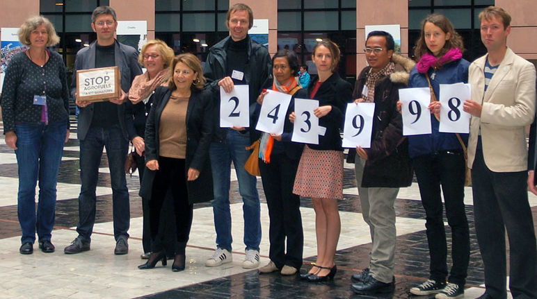 Übergabe von 243.998 Bürgerstimmen gegen Agrosprit an das EU-Parlament zusammen mit 6 NROs Umweltschützer halten Plakate mit der Anzahl der gesammelten Protestunterschriften in Straßburg in die Kamera