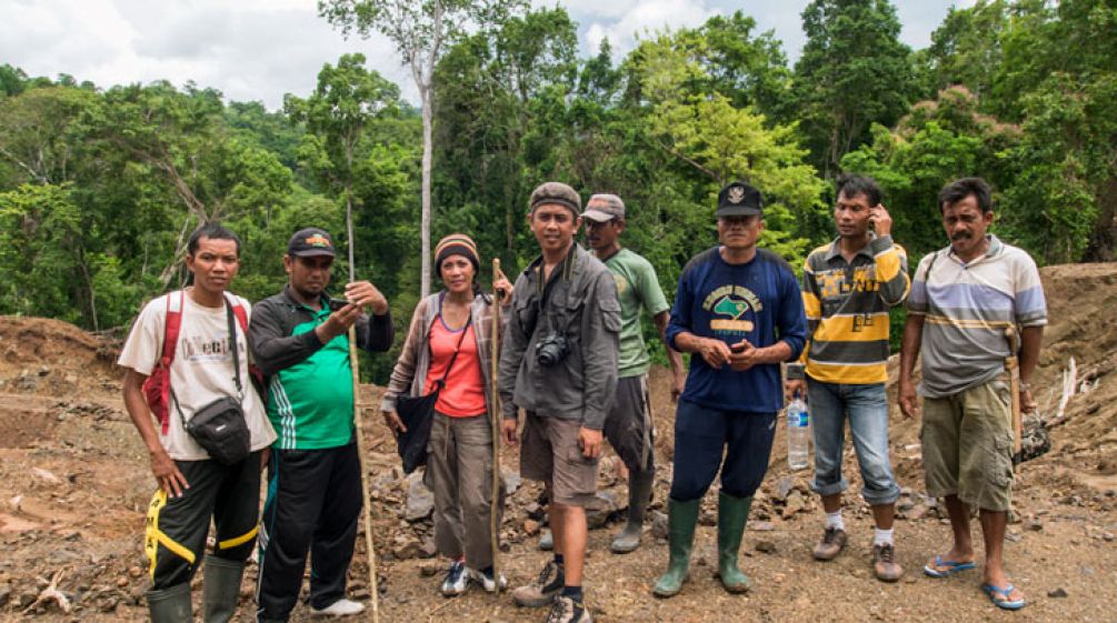 Sie haben den Regenwald in Tojo gerettet: Andika und die Dorfbewohner von Betaua Andika und Dorfbewohner vor dem geretteten Regenwald in Sulawesi