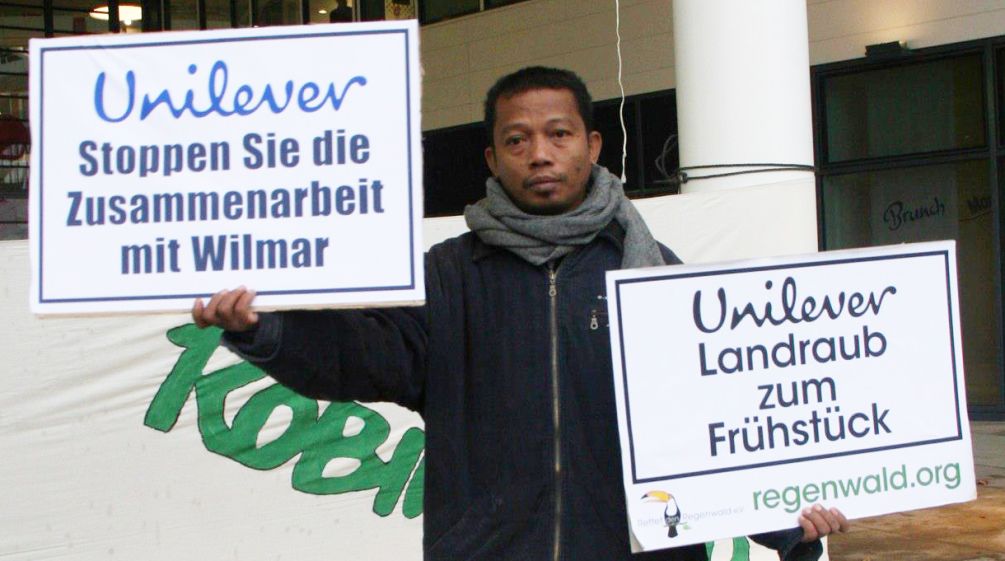 Nordin hält Demo Plakate gegen Unilver hoch
