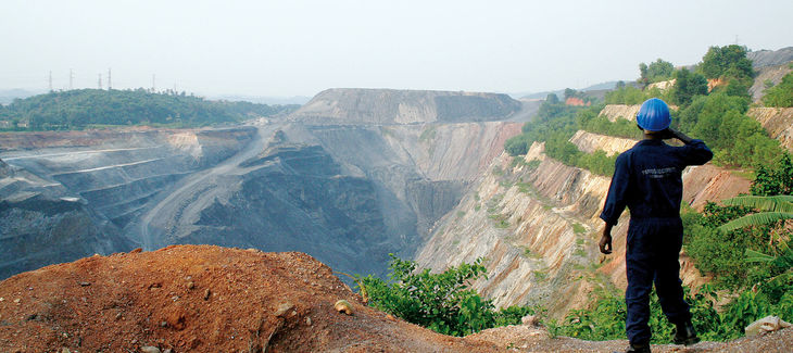 Ein Arbeiter sieht in eine große Tagebau-Mine